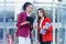 Two young female accountants walk and talk in front of the building\\\'s office.