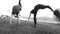 Two young female acrobat workout outdoors performing jumps