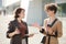 Two young female colleagues with drinks discussing working points outdoors