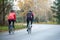 Two Young Female Cyclists Riding Road Bicycles in the Park in the Cold Autumn Morning. Healthy Lifestyle.