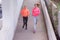 Two Young female runners in hoody  jogging in the city street.Fit body requires hard work. Urban sport concept. Two Young females