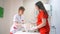 Two young female veterinarians examine a beautiful cat on the examination table.