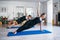 Two young females doing side plank with raised arm static strengthening core muscles in Vasisthasana position exercise on floor