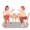 Two young females are sitting and talking in cafe