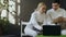 Two young fencers man and woman watching fencing competition on laptop computer and sharing experience before training