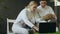Two young fencers man and woman watching fencing tutorial on laptop computer and sharing experience before training