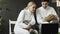 Two young fencers man and woman watching fencing tutorial on laptop computer and sharing experience before training