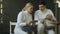 Two young fencers man and woman watching fencing tutorial on smartphone and sharing experience after training indoors