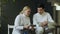 Two young fencers man and woman watching fencing tutorial on smartphone and sharing experience after training indoors