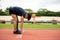 Two young Fit and confident Asian teenagers in starting position warm up stretching before running