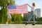 Two young friends women holding USA national flag in their hands standing together outdoors. Patriotic girls celebrating United