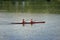 Two young girl athletes in life jackets are sailing canoe on river, controlling oars. Active outdoor sports training. Side view.