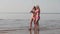 Two young girls in bikinis on the beach walk