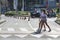 Two young girls cross a pedestrian crossing
