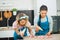 Two young girls decorating macaroons with piping bag filled with