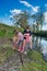 Two young girls emptying their boots of water after playing in the river.