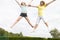 Two young girls jumping on trampoline smiling