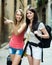 Two young girls with luggage smiling. Focus on brunette girl