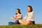 Two young girls meditate and reflect at grass