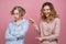 Two young girls pose for a Studio portrait on isolated background. The concept of trolling to be bullying and friendships