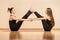 Two young girls are practicing pair yoga training holding each other hands. Concept of woman health