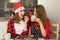 Two young girls are preparing Christmas cookies at home in the kitchen. T