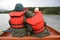 Two young girls in rain gear on canoe near Glacier Point, Aklaska.