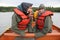 Two young girls in rain gear on canoe near Glacier Point, Aklaska.