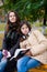 Two young girls reading in the park