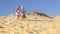 Two Young Girls Running Down Sand Dune Together