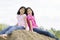 Two young girls sitting on top of haybale