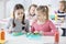 Two young girls during snack time in a school looking into each