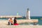 Two young girls watching the waves at the pier / harbour entrance, Lagos, Portugal