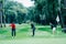 Two young golfers practicing chipping shots on a golf course with golf instructor