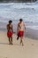 Two young guys walking along the coastline of ocean. Tourism of Asia. Australian and Asian teenagers on the beach.
