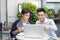 Two young handsome businessmen in casual clothes smiling, talking in coffee shop.