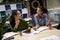 Two young and happy female coworkers sitting at the desk in the modern office and discussing project, working together