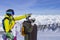 Two young happy friends snowboarders are having fun on ski slope with snowboards in sunny day