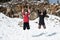 Two young happy teenage girls jumping with pleasure at snow