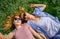 Two young happy woman doing selfie on green grass outdoor. Loving female couple lying face to face on the flowering meadow and