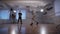 Two young hip-hop dancers participating in dance battle. Teenager in black trousers and pullover watching his friend