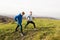 Two young hipster runners in sunny autumn nature stretching legs