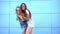 Two young hipster woman meeting and hugging over blue wall