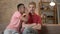 Two young homosexual boys are sitting on the couch, african guy with short hair tells the secrete to his partner, the