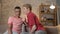 Two young homosexual boys are sitting on the couch, american guy with short hair tells the secrete to his partner, the