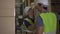 Two young industrial factory warehouse workers working in logistic industry. Asian and Indian ethnic men in hard helmet