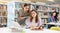 Two young interested women using laptop and books in library