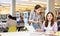 Two young interested women using laptop and books in library