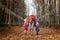 Two young little girl and his mother with blonde hair in an autumn park on a yellow and orange leaf background. Family