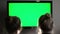 Two young long-haired blond watching green TV screen and suddenly turn their heads together